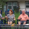 three people listening to guitar player