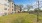 a grassy area with trees and buildings in the background