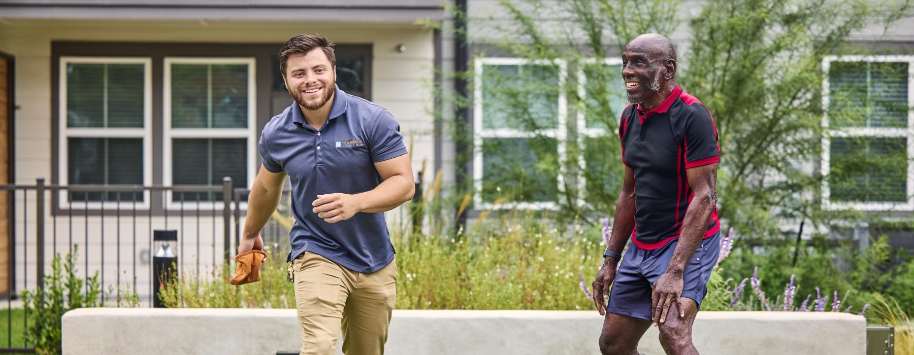 a couple of men playing corn hole
