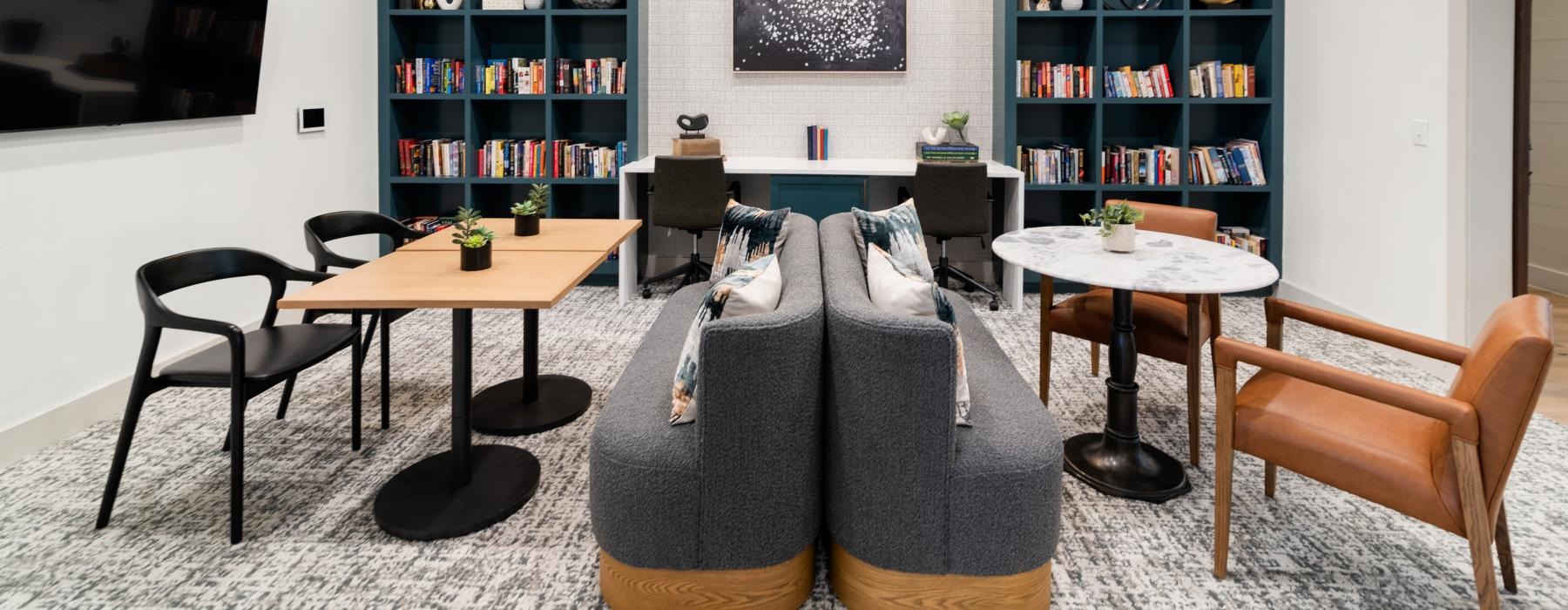 library with a table chairs and shelves